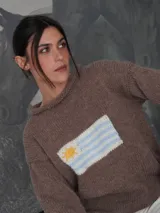 Sweater tejido a mano de color azul marino con diseño de la bandera de Uruguay en el centro del frente. Presenta un calce relajado, cuello redondo y terminaciones simples en puños y dobladillo.