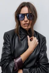 Blazer de cuero sintético negro con solapas clásicas, cierre de un botón y bolsillos frontales con solapa.