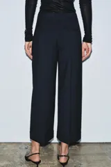 Pantalón de tiro medio confeccionado en mezcla de viscosa, con diseño de corte recto y largo tobillero. Presenta cintura con trabillas, bolsillos laterales, bolsillos traseros de vivo y cierre frontal con cremallera, botón y ganchos metálicos. El diseño incluye un sutil estampado de rayas verticales.