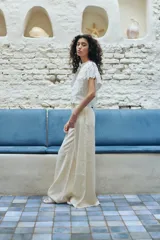 Pantalón de lino corte wide leg, tiro alto, con diseño de cinco bolsillos y cierre frontal con botón personalizado.