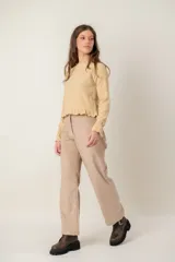 Pantalon de pana color beige, de corte recto y tiro medio, con cierre frontal y bolsillos laterales.