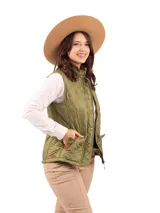 Chaleco beige capitoneado con cierre frontal y cuello de pana marrón.