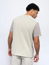 Remera deportiva Umbro de corte clásico, color gris con mangas cortas blancas y logo de la marca en el pecho.