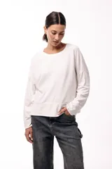 Remera de silueta amplia con hombro caído y cuello redondo, confeccionada en tejido suave de algodón. Presenta un diseño holgado y versátil con mangas largas.