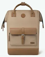 Mochila de diseño urbano en color beige con detalles en cuero sintético marrón. Cuenta con un bolsillo frontal con solapa y cierre de hebilla, asas superiores de mano y correas ajustables para hombros.