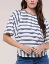 Remera de corte holgado color blanco con rayas horizontales oscuras, escote redondo a la base y mangas cortas amplias tipo murciélago. Presenta una banda ancha en el ruedo inferior con rayas verticales.