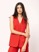 Chaleco color crema de lino con corte sastrero, largo a la cadera, forro interno, botones delanteros, silueta levemente entallada y tajo cruzado en la espalda.