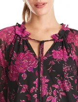 Blusa de microtul con estampado floral en tonos fucsia sobre base negra. Presenta cuello a la base con frunces, escote en V con lazo de ajuste y mangas largas con puños elastizados. Incluye forro interno a tono.