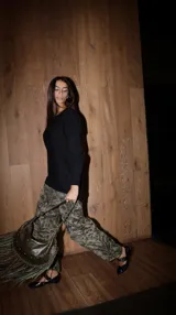 Pantalón palazzo de punto fino, tiro alto, con estampado botánico en tonos verde oliva y negro.