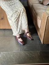 Zapatos tipo Mary Jane con punta cuadrada, confeccionados en cuero con estampado de vaca (animal print) y tira ajustable con hebilla metálica en color marrón.