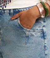 Short de jeans azul claro, estilo mom, tiro alto, con bajo doblado y recortes en los bolsillos.