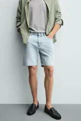 Bermuda de jean con corte regular fit, confeccionada en denim de algodón con elasticidad. Presenta diseño de cinco bolsillos, efecto lavado y cierre frontal con cremallera y botón.