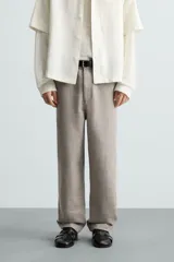 Pantalón de vestir color blanco hueso, de corte recto y tiro medio, con cintura elástica y cierre frontal de botón y cremallera. Presenta bolsillos frontales y bolsillos traseros de vivo.