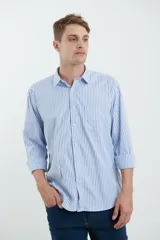 Camisa celeste y blanca a rayas verticales, de manga larga con puños abotonados y cuello clásico.