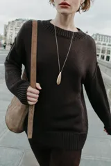 Jersey de punto con cuello redondo, manga larga con hombro caído y costuras marcadas. Presenta acabados en rib en cuello, puños y bajo.