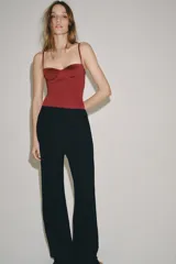 Body lencero color bordó de poliamida, con escote corazón con aro, tirantes finos regulables y cierre inferior a presión.