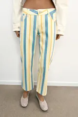 Jeans rectos de tiro bajo, confeccionados en denim con diseño de rayas verticales en tonos amarillo, celeste y rosado, estilo cropped, con cierre frontal de cremallera y botón metálico, presillas para cinto y clásico diseño de cinco bolsillos.