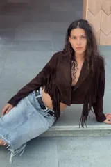 Falda midi de denim en tono azul claro, con diseño de cinco bolsillos, detalles de roturas y bajo con acabado deshilachado.