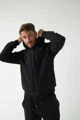 Campera de felpa negra con capucha y cordón ajustable, cierre frontal con cremallera, bolsillos laterales y logo estampado en el pecho.