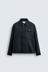 Sobrecamisa de corte regular confeccionada en tejido de algodón con estructura canvas, color negro. Presenta cuello solapa, manga larga con puño abotonado, un bolsillo frontal de plastrón y cierre frontal con botonadura oculta.