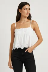 Top de algodón con diseño de broderie, corte holgado y breteles finos. Presenta un cuello recto con detalle de elástico fruncido y terminación con encaje en el ruedo.