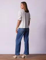 Blusa de color blanco con torso de modal y mangas cortas con detalle de bordado calado. Presenta cuello redondo con apertura central abotonada.