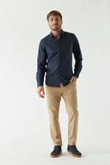 Camisa de vestir azul marino, de corte slim fit, manga larga y cuello clásico. Confeccionada en algodón y con logo bordado en el pecho.