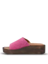 Sandalia tipo slide con capellada de gamuza en color fucsia, con plataforma de poliuretano efecto madera y plantilla de cuero marrón.