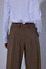 Pantalón tipo bombachita con pinzas que aportan volumen, confeccionado en Tencel. Presenta cierre frontal con botones dorados, bolsillos delanteros y ruedo ajustable mediante botón dorado.