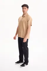 Camisa de manga corta negra, de corte clásico y cuello camisero.