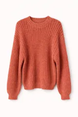 Buzo de tejido de punto grueso color naranja, con cuello redondo, mangas largas y puños acanalados.