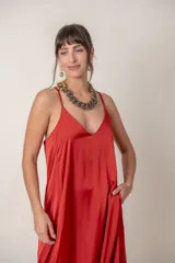 Vestido largo rojo de seda con escote en V y breteles finos. Diseño holgado con bolsillos laterales.