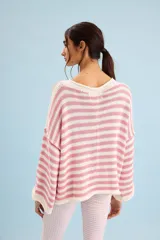 Buzo tejido de algodón con diseño a rayas horizontales en color crudo y rosado, cuello redondo y mangas anchas.