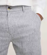 Bermuda de hombre en lino color gris claro, de corte recto, con textura discreta, bolsillos laterales y cierre frontal con botón y cremallera.