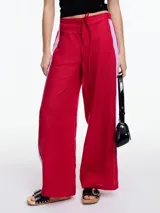 Pantalón de lino rojo con elástico en la cintura, tiro medio y calce relajado. Presenta tiras laterales en color blanco que quedan sueltas en la parte inferior.