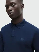 Remera polo de piqué de algodón color beige, de manga larga y corte entallado.