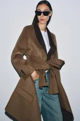 Blazer oversize de Zara Woman Collection confeccionado en mezcla de lana, con cuello sin solapa, manga larga y cierre frontal con botón. Presenta bolsillos delanteros con solapa.