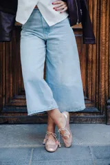 Zapato tipo blucher con diseño híbrido entre blucher y bailarina, confeccionado en piel rosada con textura de reptil. Presenta un acabado orgánico con ondas en el empeine, cierre con cordones con borlas de piel y elástico en la parte trasera para un ajuste óptimo. Cuenta con interior en piel y suela de cuero.