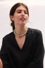 Blusa de lino negra, de corte relajado y mangas amplias, con escote en V y detalles de pespuntes en contratono.