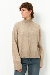 Polera de tejido de punto color bordó, con cuello alto, manga larga y costura vertical central en el frente.