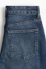 Jean tobillero de cinco bolsillos en denim de algodón levemente elástico, con tiro alto, cierre y botón, y piernas amplias.