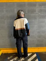 Campera negra con paneles de cuero sintético con textura de cocodrilo, corderito color crema en la parte superior y detalles en cuero marrón.