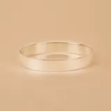 Brazalete tipo esclava de diseño minimalista y superficie lisa, confeccionado en plata 925. Presenta una estructura rígida y abierta, ideal para uso diario.