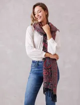 Bufandón rectangular de poliéster con estampado de arabescos en tonos rojos, azules y negros. Presenta terminaciones con flecos en los extremos.