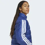 Campera acolchada de corte clásico en color azul, con cierre frontal completo y cuello alto. Presenta el logo de Adidas en el pecho y las icónicas tres tiras blancas en las mangas. Cuenta con tecnología Climawarm para aislamiento térmico y puños elásticos.