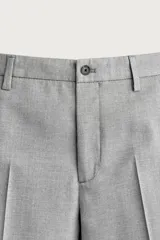 Pantalón de traje slim fit color gris, con bolsillos frontales, bolsillos traseros de doble vivo, trabillas para cinturón y cierre frontal con cremallera y botón.