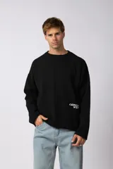 Sweater de punto liviano color negro con textura marcada, diseño de cuello redondo y calce holgado.
