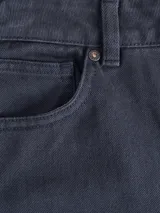 Pantalón de vestir azul marino, de corte recto, con bolsillos laterales y traseros. Se ajusta a la cintura con cinturón de cuero marrón.