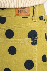 Jean de corte baggy y tiro alto, confeccionado en denim azul marino con estampado de lunares blancos, estilo barrel.