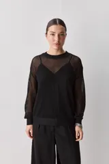 Sweater calado de punto negro, con cuello redondo y mangas largas, de diseño liviano ideal para superposiciones.